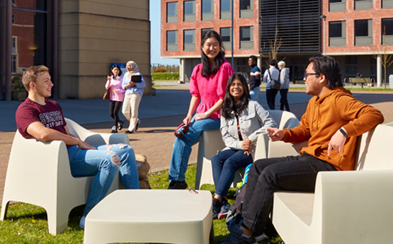 Students sitting outside chatting on Bay Campus